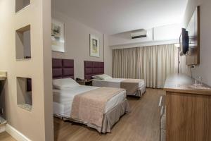 Ένα ή περισσότερα κρεβάτια σε δωμάτιο στο Hotel Victoria Villa Curitiba by Nacional Inn