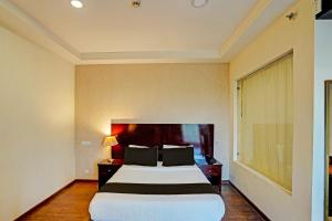 een hotelkamer met een groot bed en een raam bij Townhouse 1339 Hotel Anamika Enclave in Gurgaon