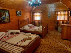 1 dormitorio con 2 camas en una cabaña de madera en Complex Țurcana Transalpina, en Şugag