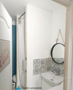 ein Badezimmer mit einem Waschbecken, einem WC und einem Spiegel in der Unterkunft Narbonne Studio Lamarobile avec jardin et terrasse proche des Grands Buffets, du centre ville et de la gare in Narbonne