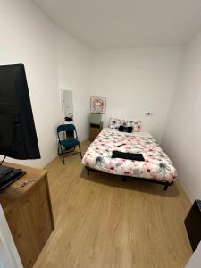 1 dormitorio con 1 cama y escritorio con TV en Loft completo, en Sant Boi del Llobregat