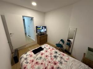 1 dormitorio con 1 cama y TV en Loft completo, en Sant Boi del Llobregat