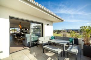 a patio with a table and chairs on a balcony at Domaine d'Arca - Gauguin 12 - 2 chambres - étage 2 in Porto-Vecchio