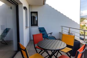 a patio with a table and chairs on a balcony at Domaine d'Arca - Gauguin 12 - 2 chambres - étage 2 in Porto-Vecchio +11 photos