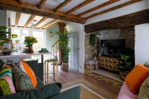 sala de estar con sofá y chimenea en Remarkable 1-Bed Cotswolds Cottage in Finstock en Chipping Norton