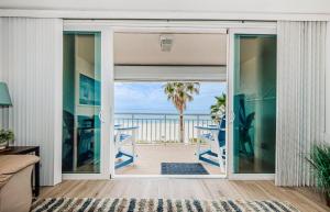 ein Wohnzimmer mit einer Glasschiebetür und Meerblick in der Unterkunft Beach Happy in Clearwater Beach