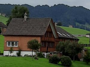 a house in a field with a green field at Ferienhaus Rütiweid in Appenzell