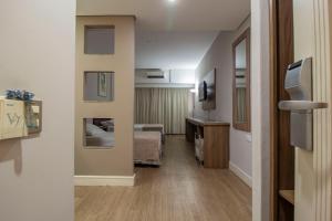 um corredor de um quarto de hotel com uma cama em Hotel Victoria Villa Curitiba by Nacional Inn em Curitiba