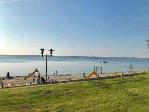 un grupo de personas en una playa con un parque infantil en Ostseewohnung Nr 14 Villa Mare, en Glücksburg