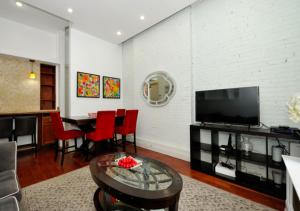 Amazing 3 BD Apartment In Mid West في نيويورك: غرفة معيشة مع تلفزيون وطاولة