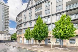 un immeuble d'appartements avec des arbres devant lui dans l'établissement Smart Central Woking 1 Bedroom Apartment, à Woking