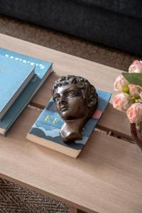 a bronze bust on a table next to books at Queens Courtyard by Daniel&Jacob's in Copenhagen