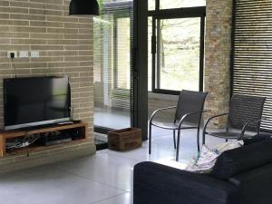 ein Wohnzimmer mit einem TV und 2 Stühlen in der Unterkunft Finca Los Polines en Tarso in Tarso