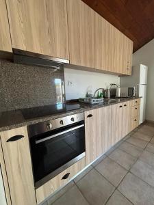 una cocina con armarios de madera y horno negro en Casa da Alagoa, en Batalha