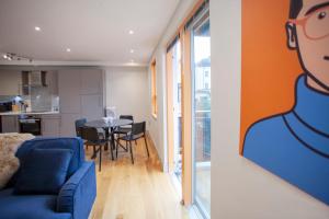 uma sala de estar com um sofá azul e uma mesa em higgihaus Cabot Mews #29 Fantastic Central Location em Bristol