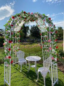 an arbor with a table and chairs in a garden at The P2 Hotel in Mae Sot