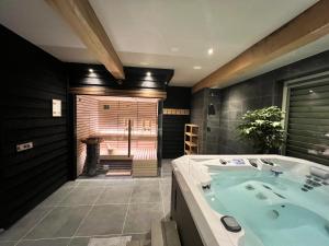 uma casa de banho com uma banheira grande e uma cabina de duche ao nível do chão em B&B Eindeloos em Opeinde