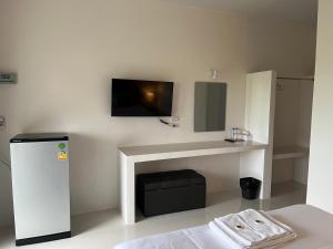 a room with a tv on a wall with a fireplace at The P2 Hotel in Mae Sot