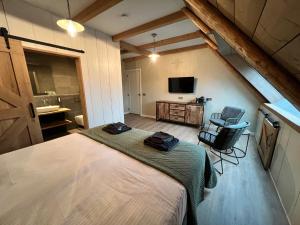 een slaapkamer met een bed en een televisie in een kamer bij B&B Eindeloos in Opeinde