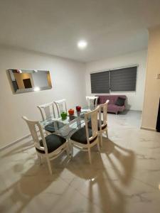 uma sala de jantar com uma mesa de vidro e cadeiras em Apartamento excelente ubicación em Barranquilla