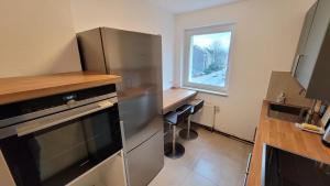 a kitchen with a stainless steel refrigerator and a window at Wohnung in Datteln in Datteln