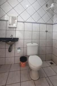 ein Badezimmer mit einem weißen WC und einem Waschbecken in der Unterkunft Hotel Los Angeles Aeroporto in Várzea Grande