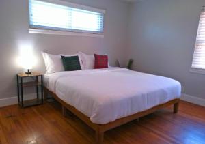 um quarto com uma grande cama branca e 2 almofadas em Cozy 3br By Houston Ship Channel em Houston