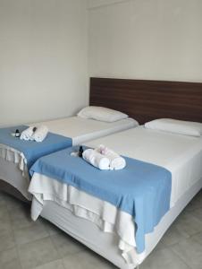 two beds with towels and stuffed animals on them at Villa Del Sol Hotel Fortaleza in Fortaleza