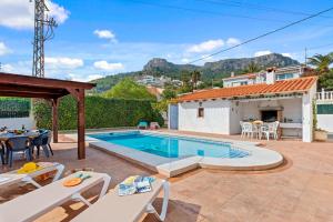 a villa with a swimming pool and a patio at Villa Mercedes - Plusholidays in Calpe