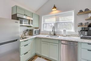a kitchen with green cabinets and a sink at Charming Cottage at Waxahatchee Creek and Marina! in Shelby
