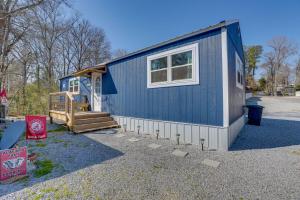 a blue tiny house with a porch and a staircase at Charming Cottage at Waxahatchee Creek and Marina! in Shelby