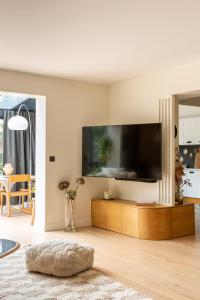 sala de estar con TV de pantalla plana grande en Maison d'architecte Paris/Disney, en Bry-sur-Marne