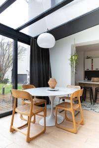 comedor con mesa blanca y sillas en Maison d'architecte Paris/Disney, en Bry-sur-Marne