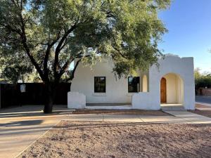 una pequeña casa blanca con un árbol y una acera en Sam Hughes Desert Oasis, Private Pool & Walk to UA, en Tucson