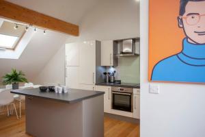 a kitchen with a painting of a man on the wall at higgihaus Cabot Mews #32 Sunday - Friday Central Location in Bristol