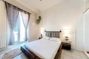 a white bedroom with a bed and a window at B&B Camera a Sud Iris in Trani