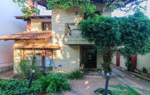 a brick house with a tree in front of it at Refúgio Arioli in Porto Alegre