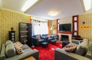 a living room with two couches and a television at Refúgio Arioli in Porto Alegre