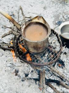 uma xícara de café sentado em cima de uma lareira em Orion's wild camp em Dana