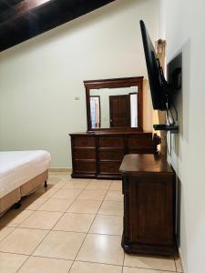 1 dormitorio con 1 cama y vestidor con TV en Casa Primavera SPS en San Pedro Sula