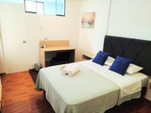 una camera da letto con un letto grande con cuscini blu di Hermosa Habitación c/ Baño privado - Huacachina. a Ica