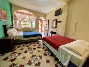 a bedroom with two beds and a tiled floor at Gutierrez Hotel in Panajachel