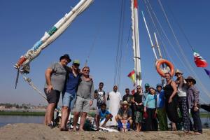 a group of people standing in front of a boat at Felucca Sailing Boat Overnight Experience in Aswan