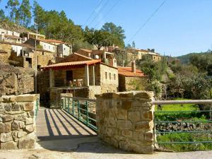 a building with a fence in front of a village at 2 bedrooms house at Vila de Rei in Vila de Rei