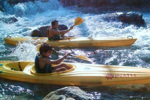 two people in kayaks in the water on a river at 2 bedrooms house with terrace at Vila de Rei in Vila de Rei