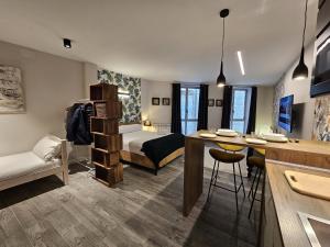 a room with a bed and a kitchen with a table at TuApartamento Loft - Fuente de Navarrería in Pamplona