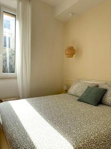 a bedroom with a bed and a window at La Maison in Civitavecchia