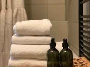 a stack of towels and two bottles of wine at Guesthouse De Wissen in Dilsen-Stokkem