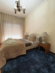 a bedroom with a bed and a table with a lamp at Art Gallery Apartment in Porto