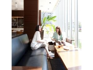 two women sitting on a couch in a living room at Hotel day by day - Vacation STAY 93897 in Hamamatsu